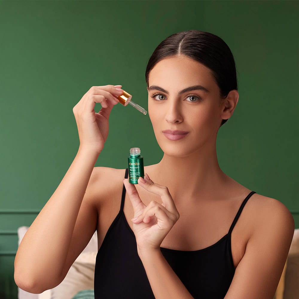 Model applying skincare serum beautifully captured through product photography at a quality photo studio