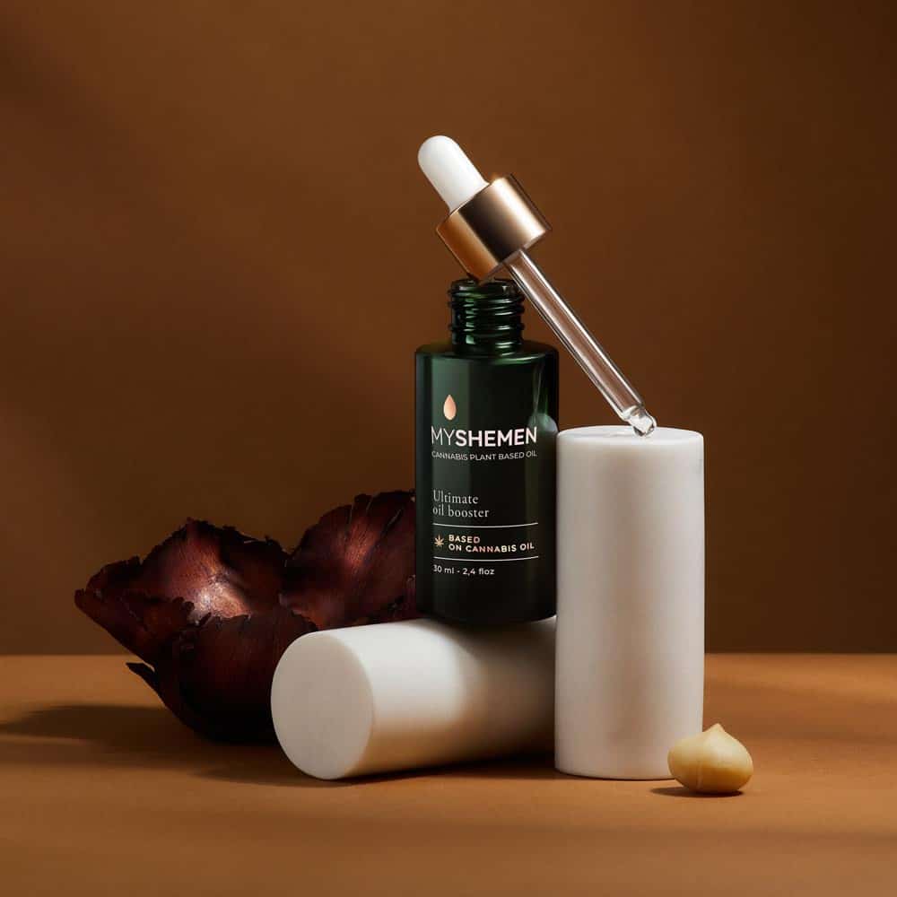 ultimate oil booster bottle showcases makeup cosmetics photography against photography for advertising warm amber tones